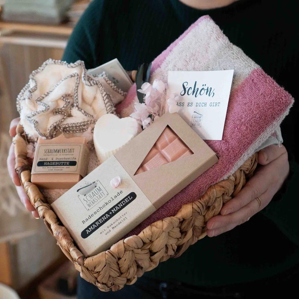 Wellnesset in einer Herzschale mit rosafarbenen Handtuch, Salzseife in Herzform, Seife Hagebutte und Badeschokolade Amarena-Mandel