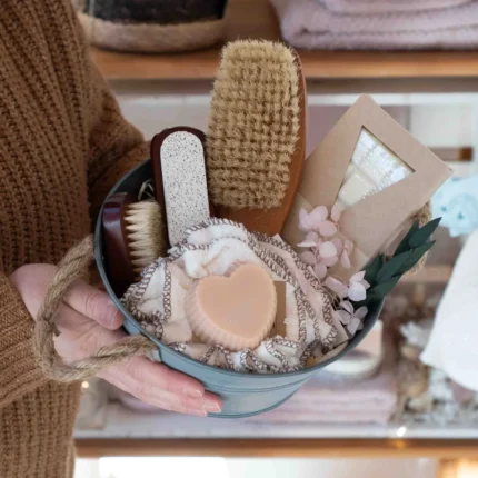 Set für die Badewanne: Zinkwanne gefüllt mit Naturbürsten, Naturseife in Herzform und Badeschokolade
