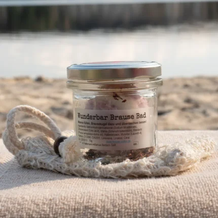 Badekugel Beere im Glas mit Beerenduft auf Handtuch am Wasser arrangiert